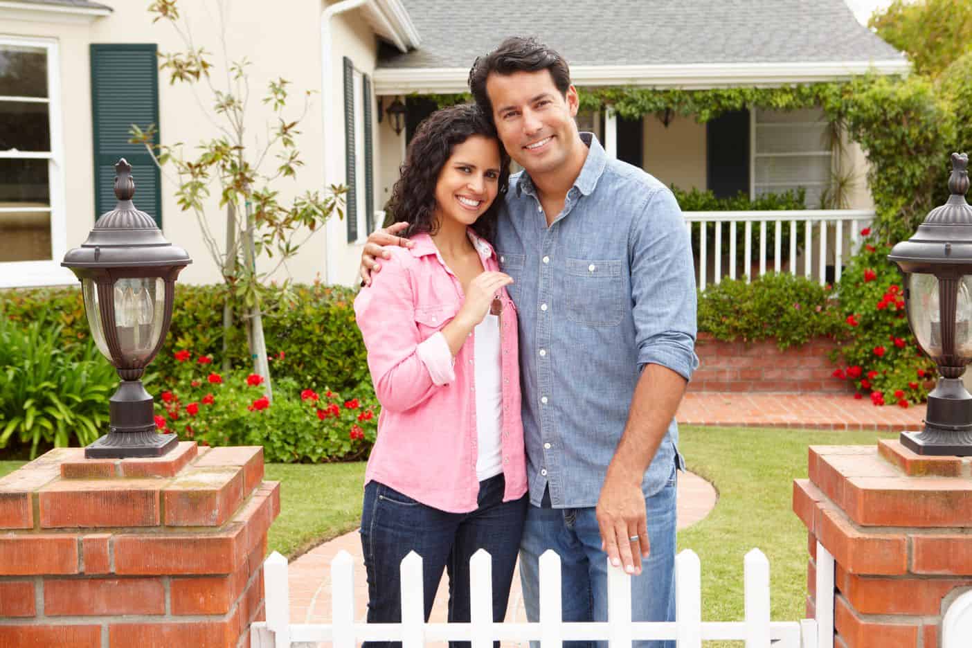 Young couple in front of suburban home